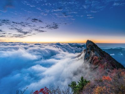 远山云海之间的石阶小路，一人背剑独行，天边泛着青绿色微光，画面开阔辽远